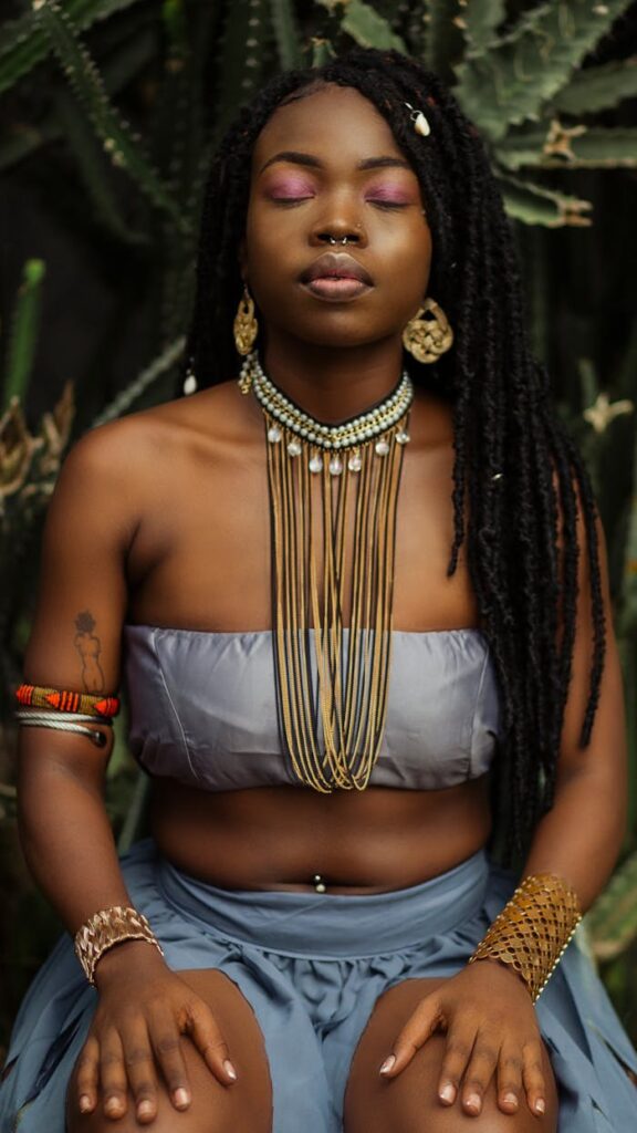 Elegant portrait of a Nigerian woman in traditional jewelry, outdoors.
