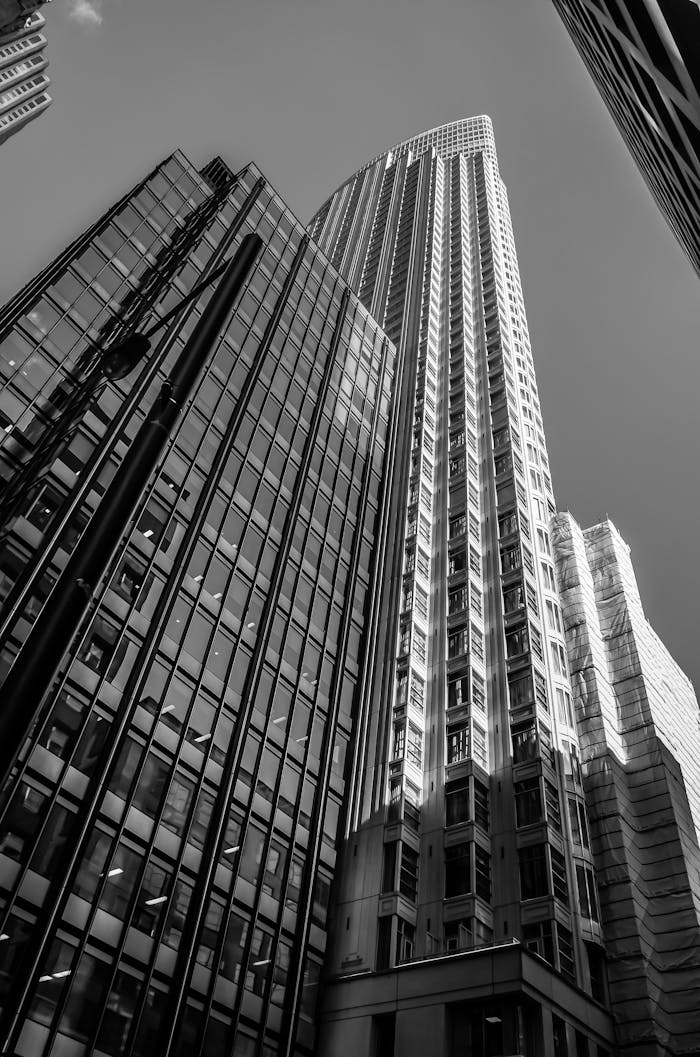 A dramatic low angle view of towering skyscrapers in monochrome.